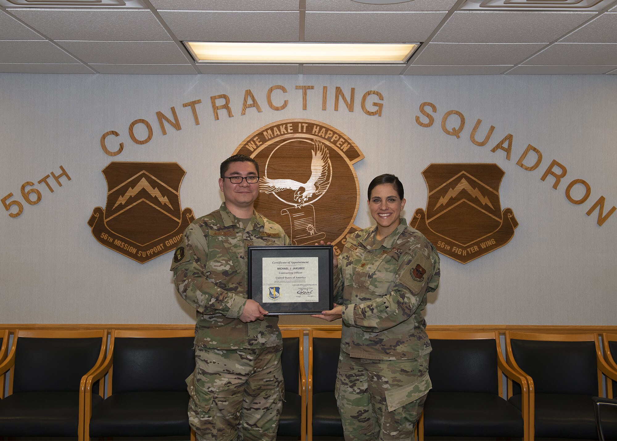 Tech. Sgt. Michael Jakubec, 56th CONS noncommissioned officer in charge of services flight, receives an unlimited contract warrant certificate from Maj. Barbara Divine, 56th Contracting Squadron commander, Sept. 26, 2019, at Luke Air Force Base, Ariz.