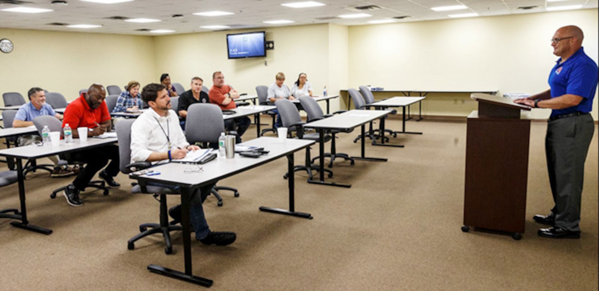 Man speaks with an audience in a room