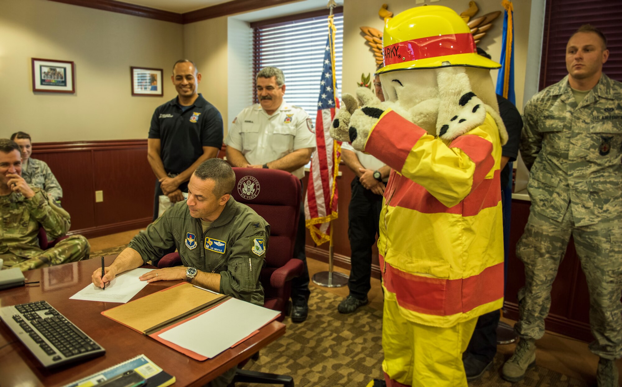 Col Lee Gentile, 47th Flying Traiining Wing commander, signs the Fire Prevention Week Proclamation as Sparky gives the "thumbs-up" Sept. 25, 2019 at Laughlin  Air Force Base, Texas. Gentile and base firefighters promoted the importance of fire saftey, as well as the upcoming FPW, which starts Oct. 7 - 11.  (U.S. Air Force photo by Master Sgt JT May III)