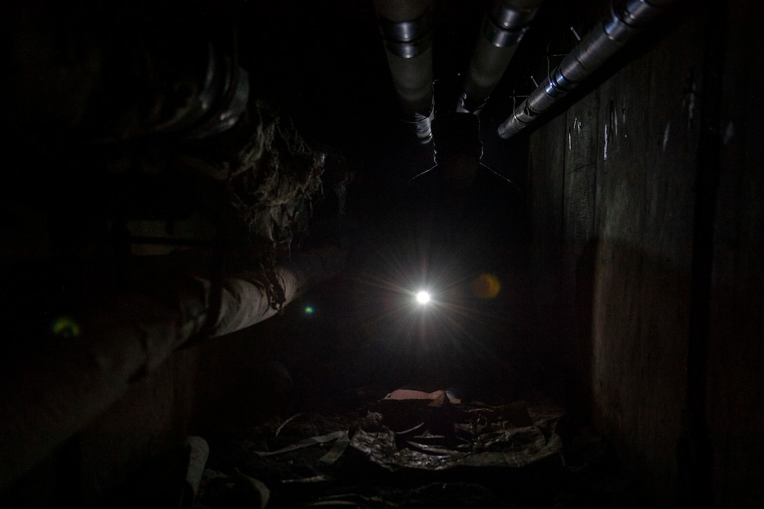Staff Sgt. Cory Schollmeyer, 23d Civil Engineer Squadron pest management, crawls through a tunnel while conducting a survey treatment underneath a building Sept. 10, 2019, at Moody Air Force Base, Ga. Pest management, known as entomology, uses survey treatments to keep facilities free of pest-related health hazards, helping Moody’s Airmen stay mission ready. (U.S. Air Force photo by Airman Azaria E. Foster)
