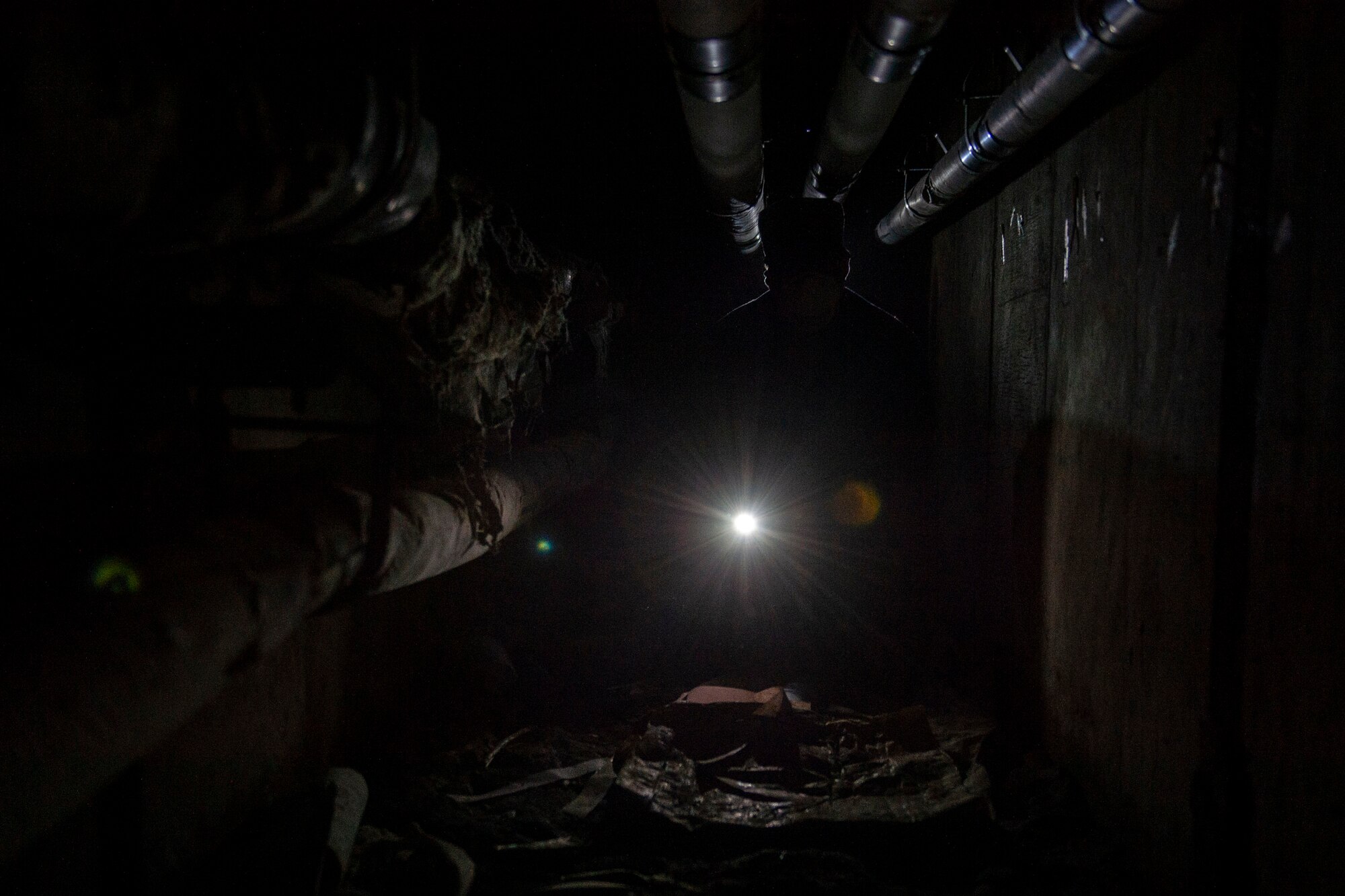 Staff Sgt. Cory Schollmeyer, 23d Civil Engineer Squadron pest management, crawls through a tunnel while conducting a survey treatment underneath a building Sept. 10, 2019, at Moody Air Force Base, Ga. Pest management, known as entomology, uses survey treatments to keep facilities free of pest-related health hazards, helping Moody’s Airmen stay mission ready. (U.S. Air Force photo by Airman Azaria E. Foster)