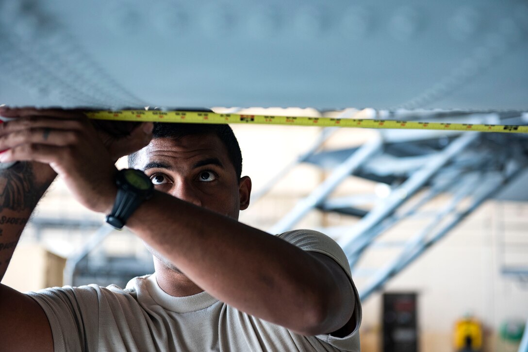 Staff Sgt. Aaron Nazario, 71st Aircraft Maintenance Unit crew chief, measures the spacing for shorings during preparation of an HC-130J Combat King II for a situational awareness communication upgrade (SACU) modification Sept. 25, 2019, at Moody Air Force Base, Ga. The shorings allow the aircraft to be put into a state of no-loading”, where the pressure and weight of the aircraft will be reduced, allowing the modifications to be implemented without damage to the aircraft’s hull integrity. This SACU will enhance the aircraft’s ability to communicate with personnel on the ground during search and rescue operations. (U.S. Air Force photo by Senior Airman Erick Requadt)