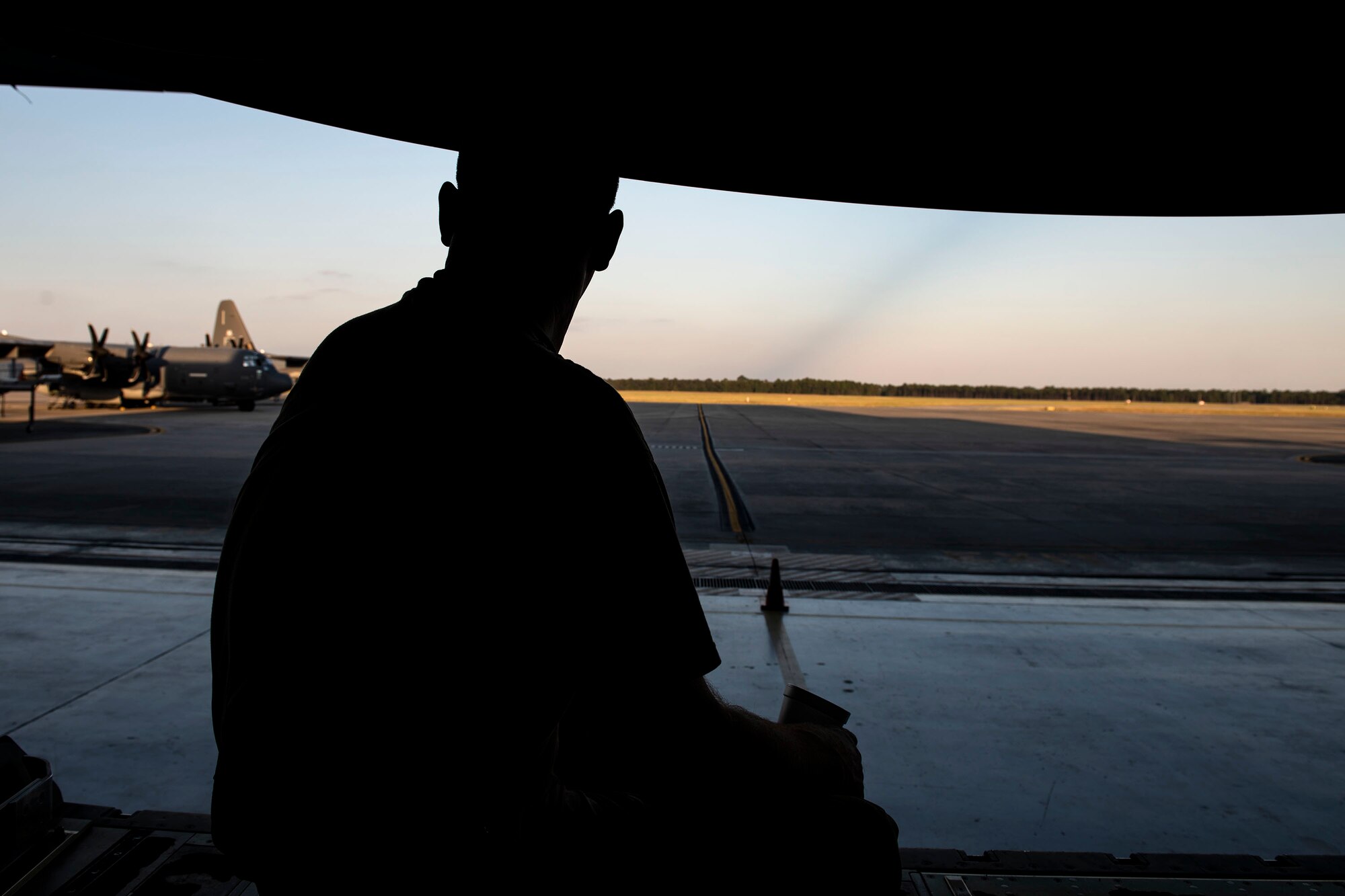 Tech. Sgt. Phillip Horton, 71st Aircraft Maintenance Unit crew chief, looks out onto the flightline after removing cargo floor panels during preparation of an HC-130J Combat King II for a situational awareness communication upgrade (SACU) modification Sept. 25, 2019, at Moody Air Force Base, Ga. The panels are removed to allow access to the area inside the aircraft where the SACU will be installed. This SACU will enhance the aircraft’s ability to communicate with personnel on the ground during search and rescue operations. (U.S. Air Force photo by Senior Airman Erick Requadt)