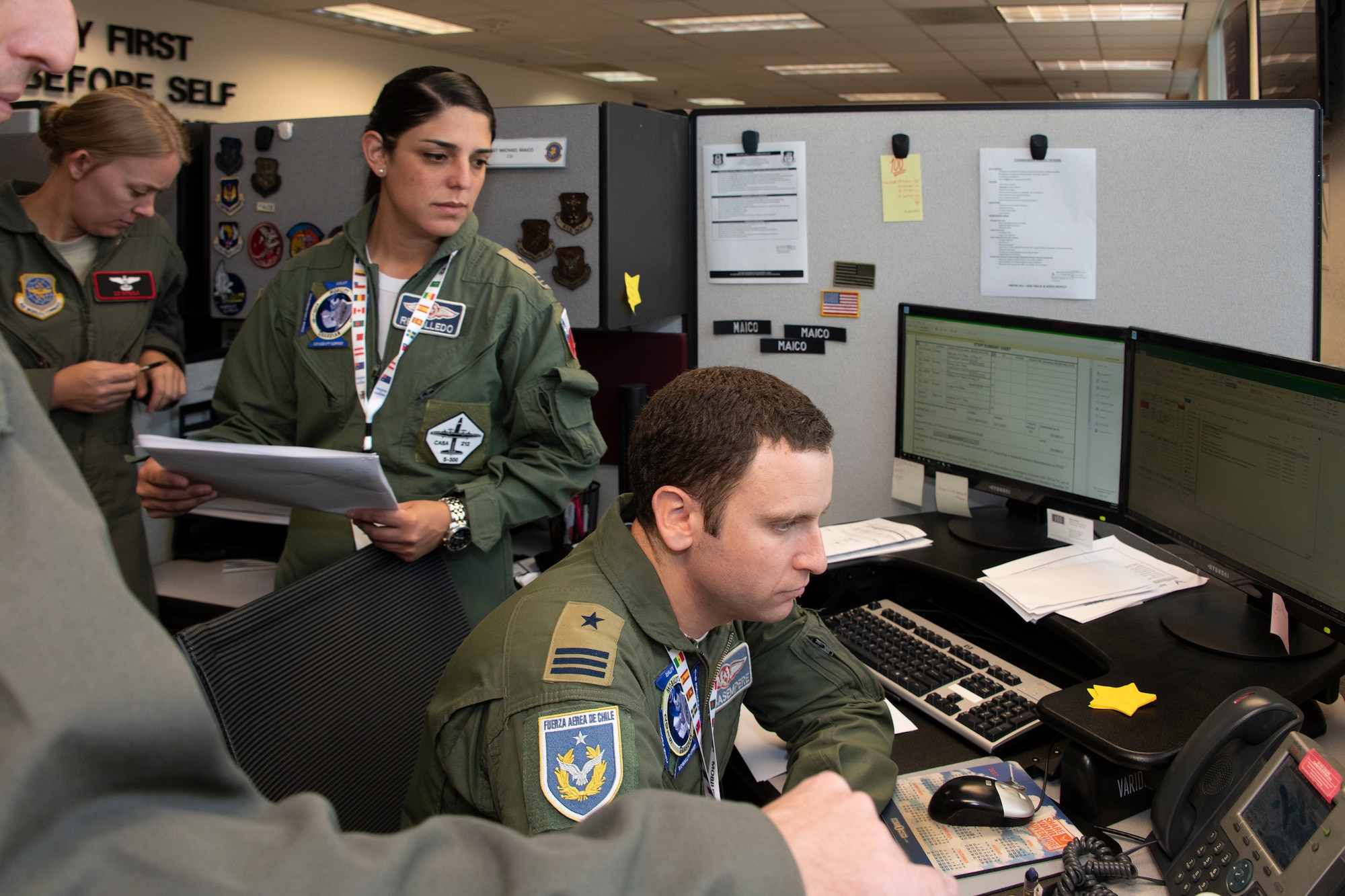 Chilean Air Force Capts. Romina Rebolledo, C-212 transport pilot and liaison  officer to the Brigade General and Felipe Casasempere, F-16 pilot and chief of planning for the 3rd Squadron, listen to a phone call during exercise Mobility Guardian Sept. 25, 2019, at Travis Air Force Base, California. MG19 is Air Mobility Command’s full spectrum readiness exercise, designed to strengthen and improve integrated teamwork. U.S. aircraft joined aircraft from more than two dozen nations along with more than 4,000 U.S. and international Air Force, Army, Navy, and Marine Corps service members. (U.S. Air Force photo by Heide Couch)