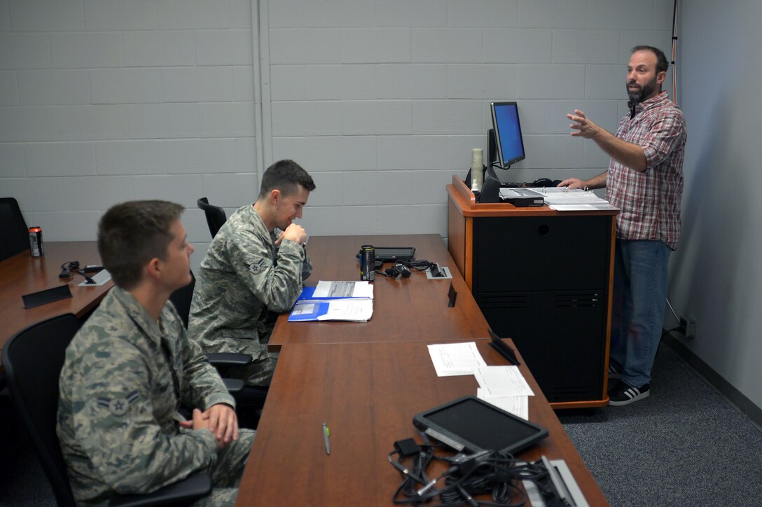 Darryl Ebsch, a civilian instructor, goes over radio frequency distribution with two Airmen assigned to the 55th Aircraft Maintenance Squadron.