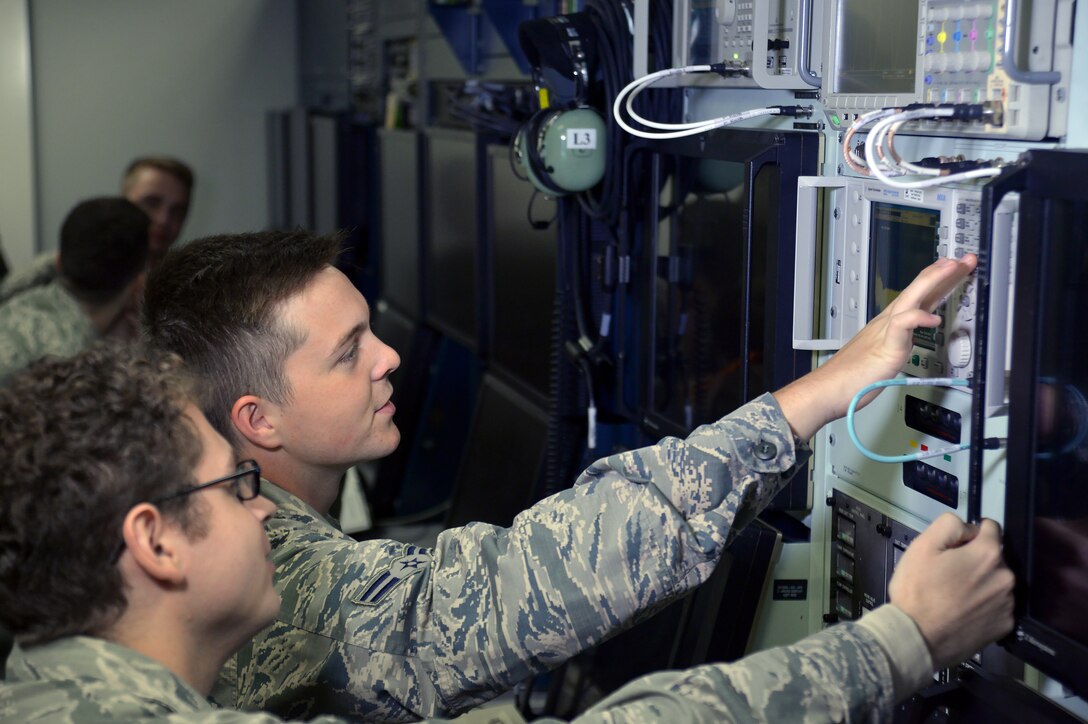 Two Airmen train on replica of an aircraft computer system.