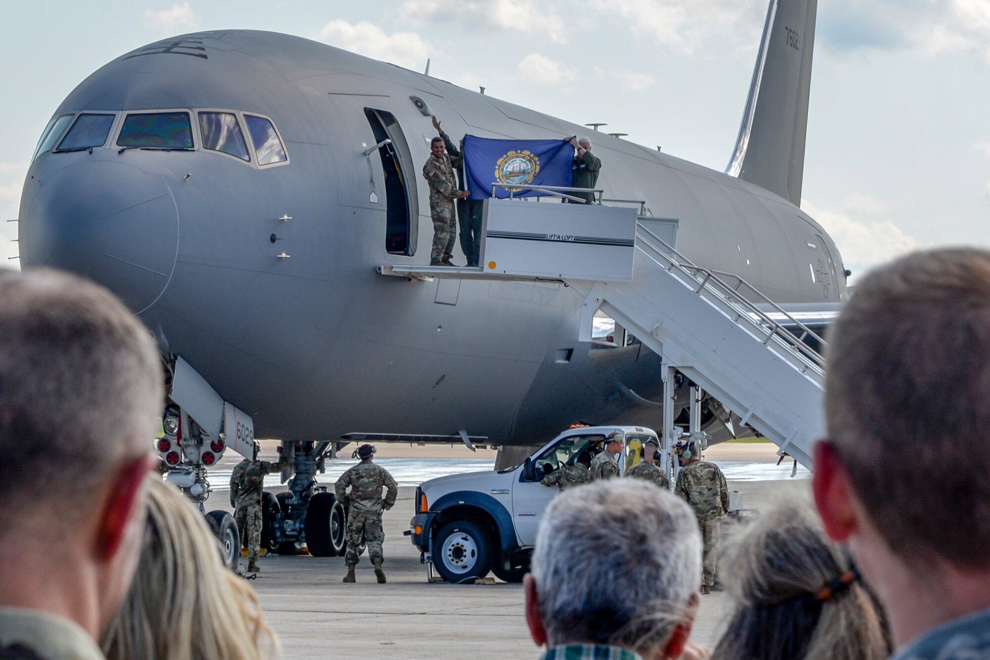 Lt. Gen. L. Scott Rice, Director of the Air National Guard, Maj. Gen. David Mikolaities, Adjutant General of New Hampshire, and Brig. Gen. Laurie Farris, Commander of the New Hampshire Air National Guard, hold up a NH state flag as they exit the first delivered KC-46 Pegasus to Pease Air National Guard Base, NH, Aug. 8, 2019. The Pegasus forges a new era at Pease marking the first upgrade to its aircraft inventory in decades.(U.S. Air National Guard photo by Senior Airman Taylor Queen)