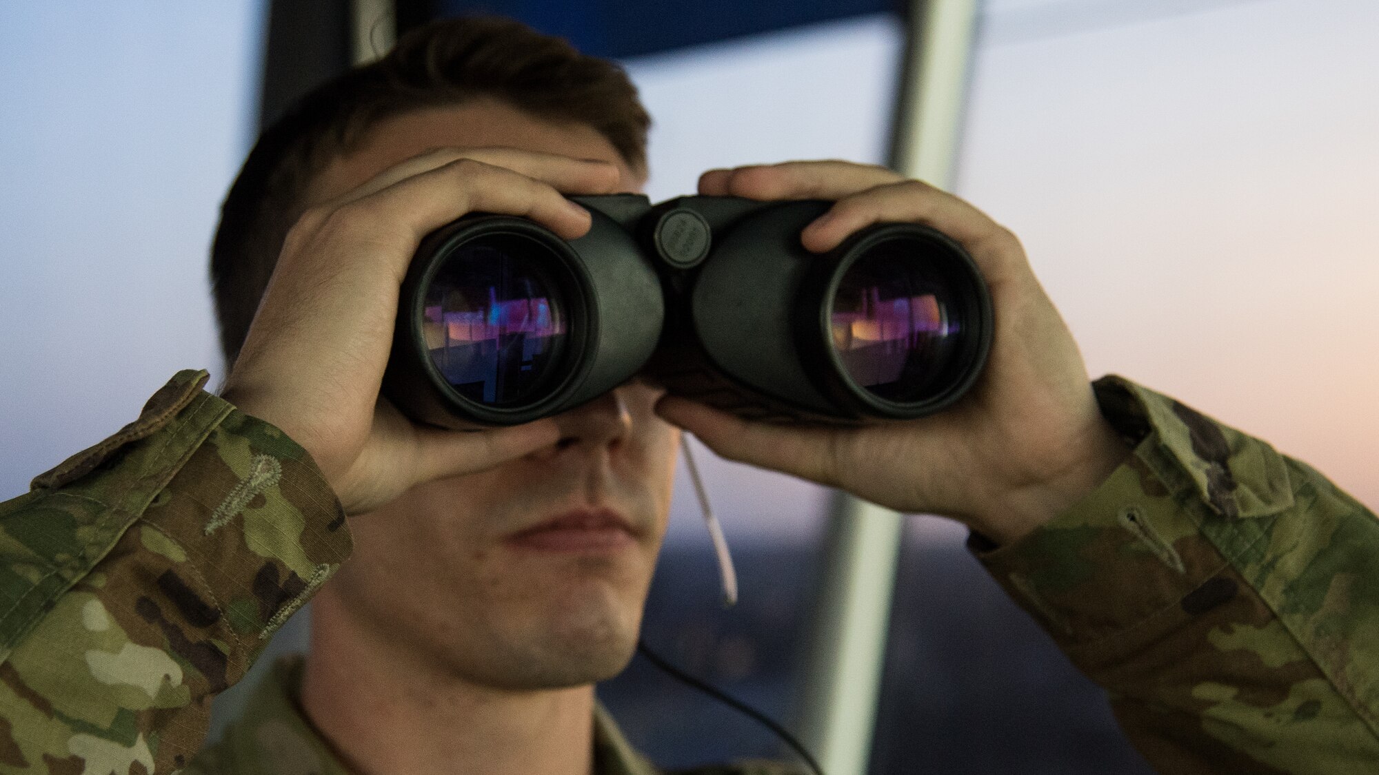 Senior Airman Hunter J. Maggard, 2nd Operations Support Squadron air traffic control apprentice, uses his binoculars to locate an aircraft on the flightline at Barksdale Air Force Base, Louisiana, August 22, 2019.
