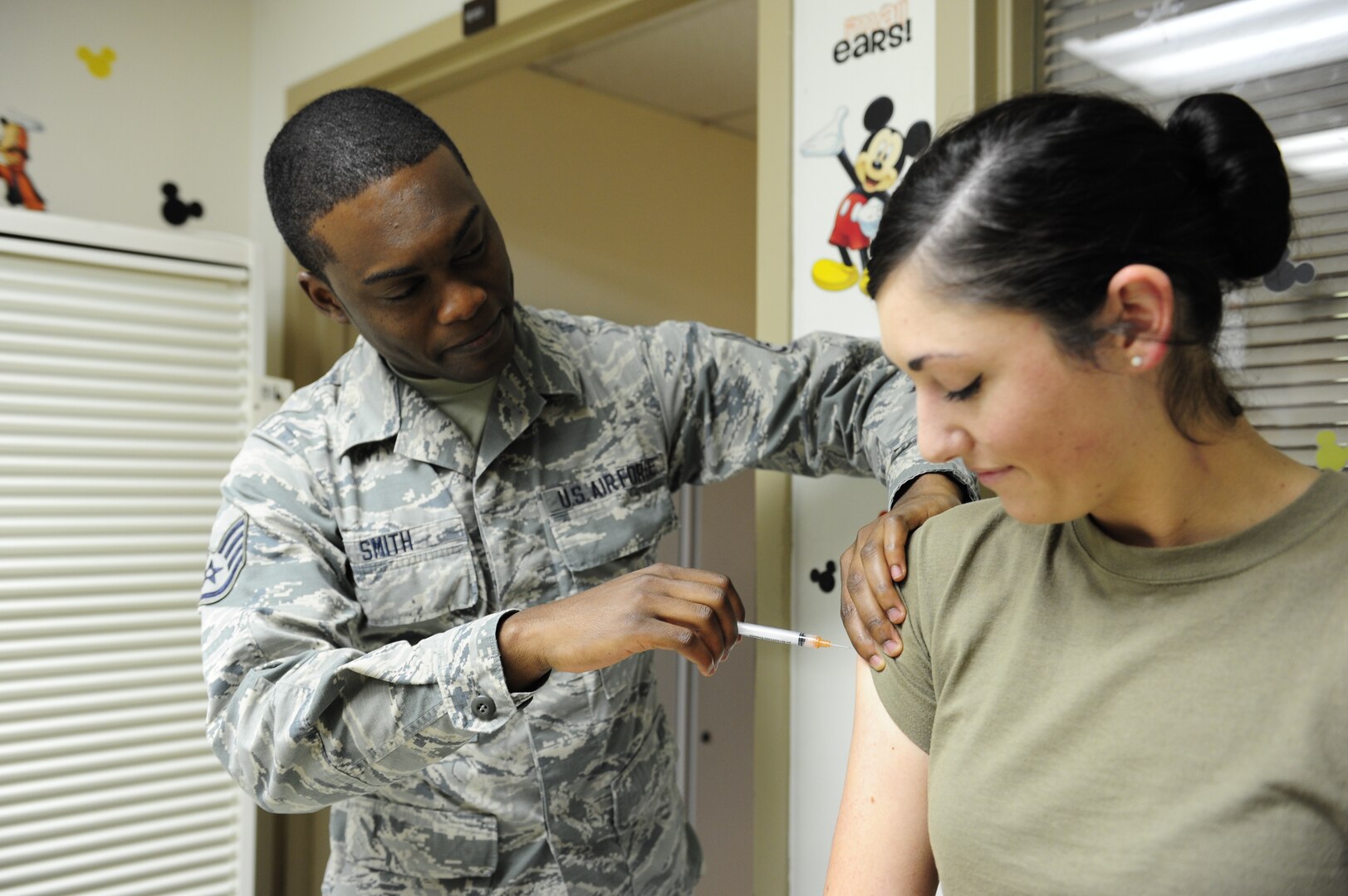 Staff Sgt. Hakeem Smith, 359th Medical Operations Squadron Immunization Clinic NCO in charge, simulates giving an immunization to Senior Airman Kayli O’Keefe, 359th MDOS medical technician, at the Joint Base San Antonio-Randolph clinic, Sept. 25, 2019. With flu season quickly approaching, health care professionals throughout JBSA are encouraging beneficiaries to receive their flu shots once the vaccines are available. The flu is spread throughout the year, but is most common during the fall and winter months. Influenza activity typically begins to increase in October and November, peaking during the winter months and continuing as late as May.