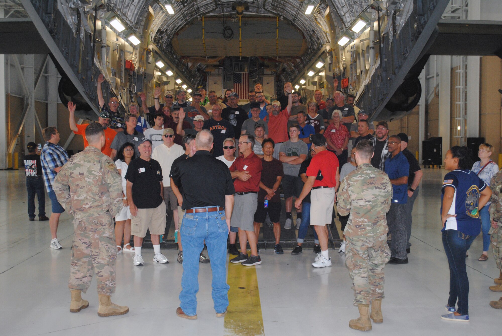 A maintenance Airman talks about a C-5M Super Galaxy to civilians and veterans inside the C-5M.