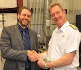 IMAGE: DAHLGREN, Va. (Sept. 25, 2019) - British Royal Navy Second Sea Lord Vice Adm. Nicholas Hine shakes hands with Dr. Chris Lloyd, High Energy Laser Lethality lead at Naval Surface Warfare Center Dahlgren Division (NSWCDD) during a presentation held after a live test demonstration. Lloyd presented the second sea lord with a steel metal sample irradiated and penetrated in the command’s High Energy Laser Lethality laboratory. NSWCDD subject matter experts briefed Hine and his delegation on programs and capabilities that included the NSWCDD Innovation Lab, digitalization of the U.S. Navy, high velocity tactical development, and directed energy weapons such as the high energy laser, electromagnetic railgun, and hyper-velocity projectile.  (U.S. Navy photo/Released)