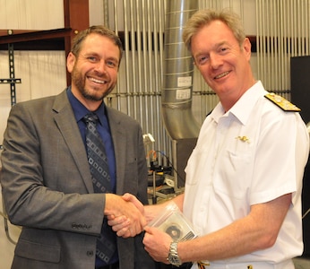 IMAGE: DAHLGREN, Va. (Sept. 25, 2019) - British Royal Navy Second Sea Lord Vice Adm. Nicholas Hine shakes hands with Dr. Chris Lloyd, High Energy Laser Lethality lead at Naval Surface Warfare Center Dahlgren Division (NSWCDD) during a presentation held after a live test demonstration. Lloyd presented the second sea lord with a steel metal sample irradiated and penetrated in the command’s High Energy Laser Lethality laboratory. NSWCDD subject matter experts briefed Hine and his delegation on programs and capabilities that included the NSWCDD Innovation Lab, digitalization of the U.S. Navy, high velocity tactical development, and directed energy weapons such as the high energy laser, electromagnetic railgun, and hyper-velocity projectile.  (U.S. Navy photo/Released)