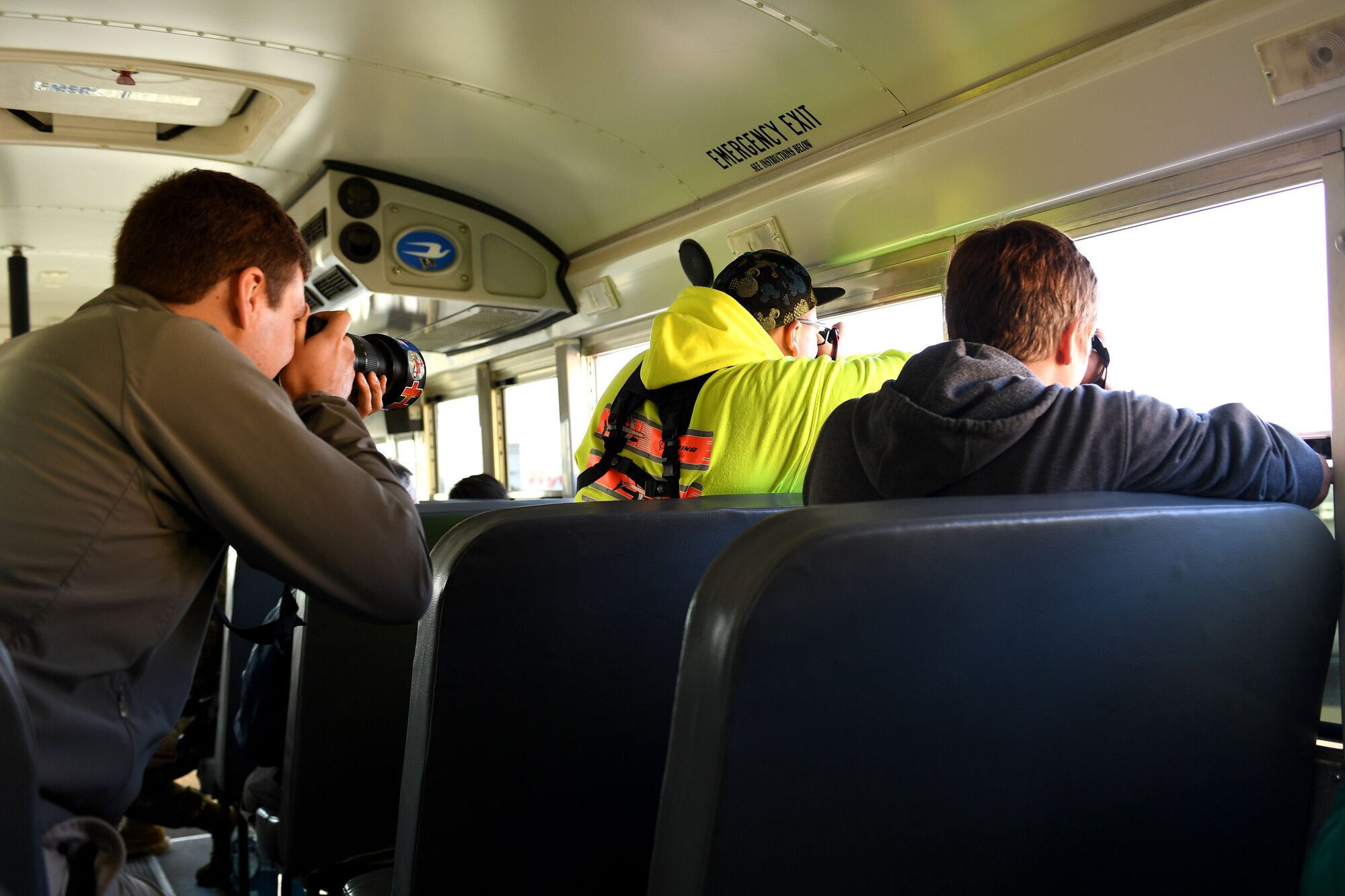 People take photos out of a bus window.