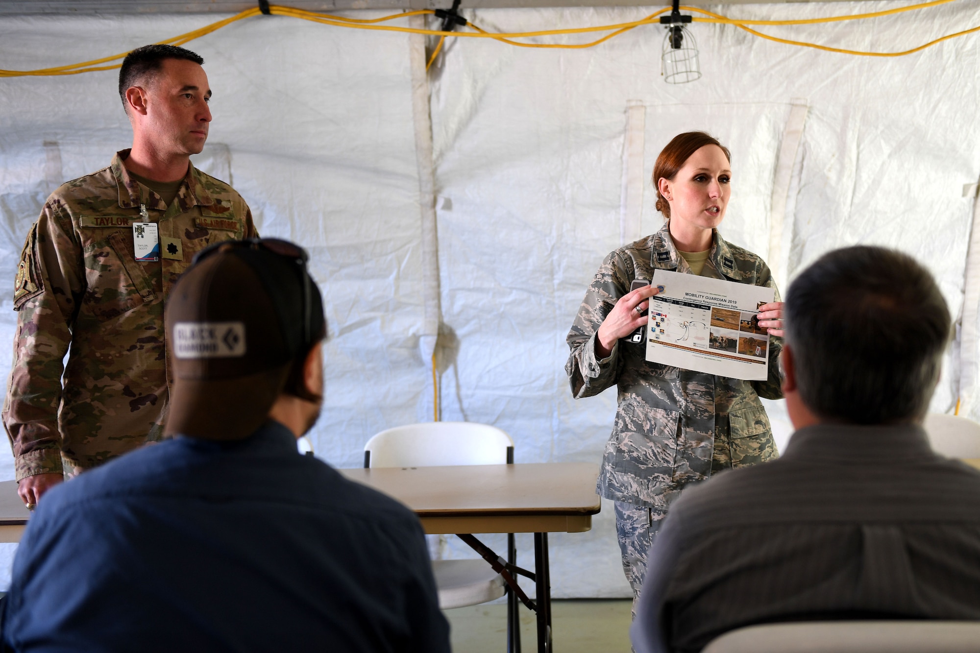 A woman talks to a group of people.