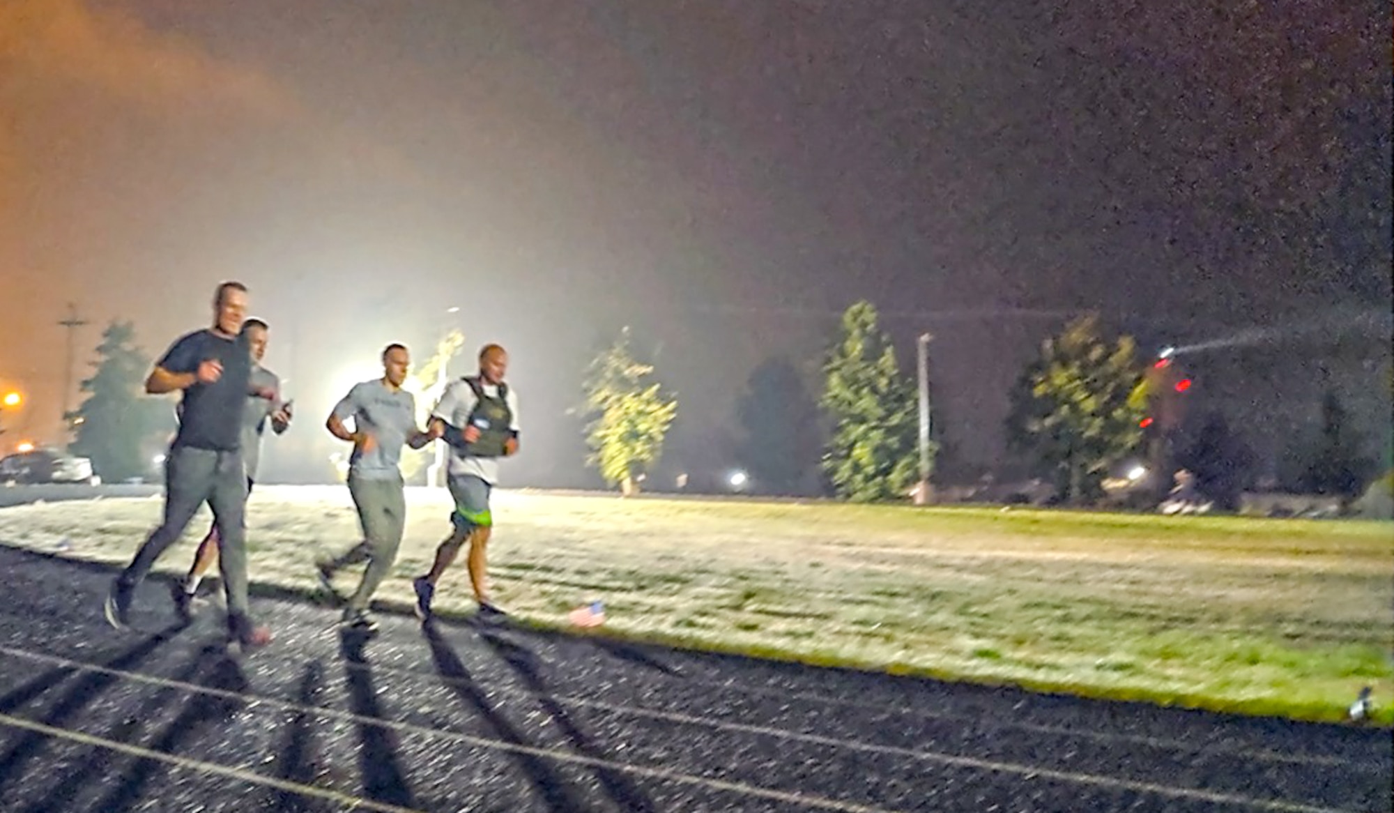 Members of the 225th Air Defense Squadron, lead by their commander Col. Brian Bergren (left), run during the early morning hours Sept. 19, 2019 during the POW/MIA Remembrance Run on Joint Base Lewis-McChord. (Courtesy photo)