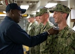Command Master Chief De'Andre Beaufort performs a uniform inspection on the engineering department's repair division Sailors as part of Division in the Spotlight aboard the aircraft carrier USS Gerald R. Ford (CVN 78) at Newport News, Virginia.