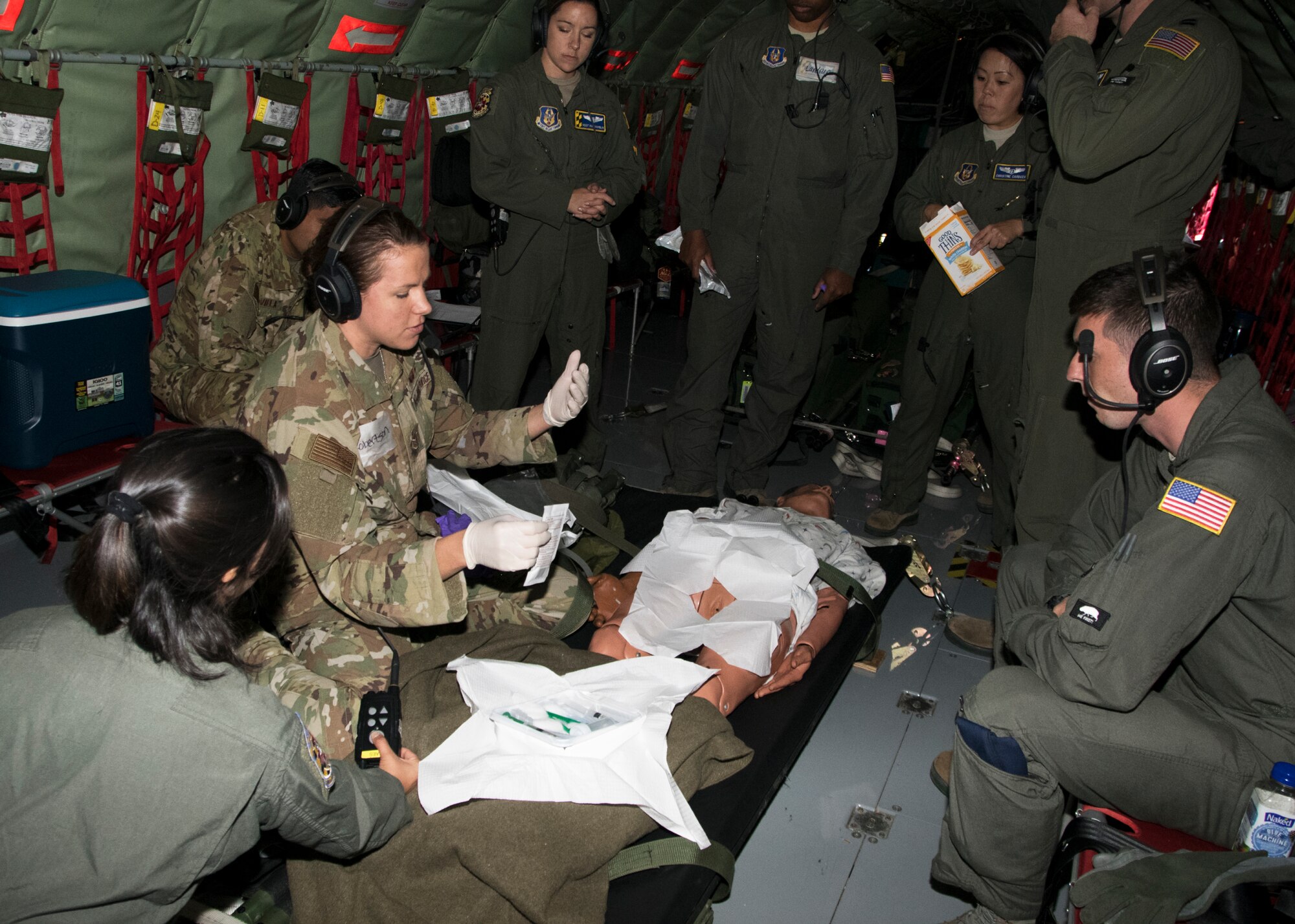 Staff Sgt. Sarah Loudon, 459th Aeromedical Evacuation Squadron flight medic, demonstrates an indwelling foley catheter, to team members during an off station trainer on a KC-135 Stratotanker, Sept. 20, 2019. The team participates in local and off station training missions about twice a month to ensure humanitarian and deployment mission readiness. (U.S. Air Force photo by Staff Sgt. Cierra Presentado/Released)