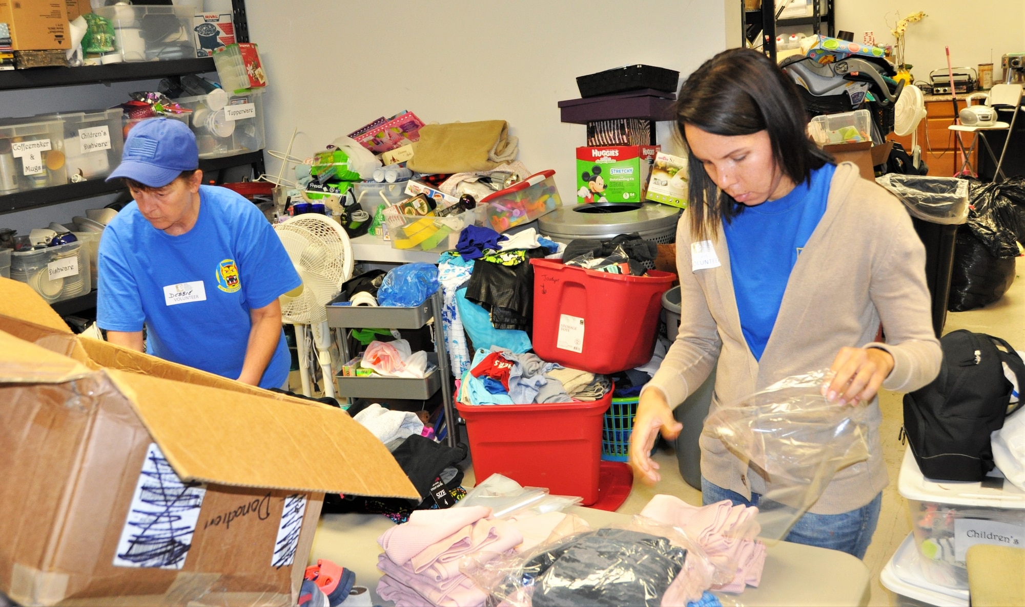 Debbie Gildea (left) and Master Sgt. Angelina Manby sort clothing during a 340th Flying Training Group community outreach event Sept. 11 at the San Antonio, Texas Family Violence Prevention Services/Battered Women and Children’s Shelter’s Donation Center. (U.S. Air Force photo by Janis El Shabazz)