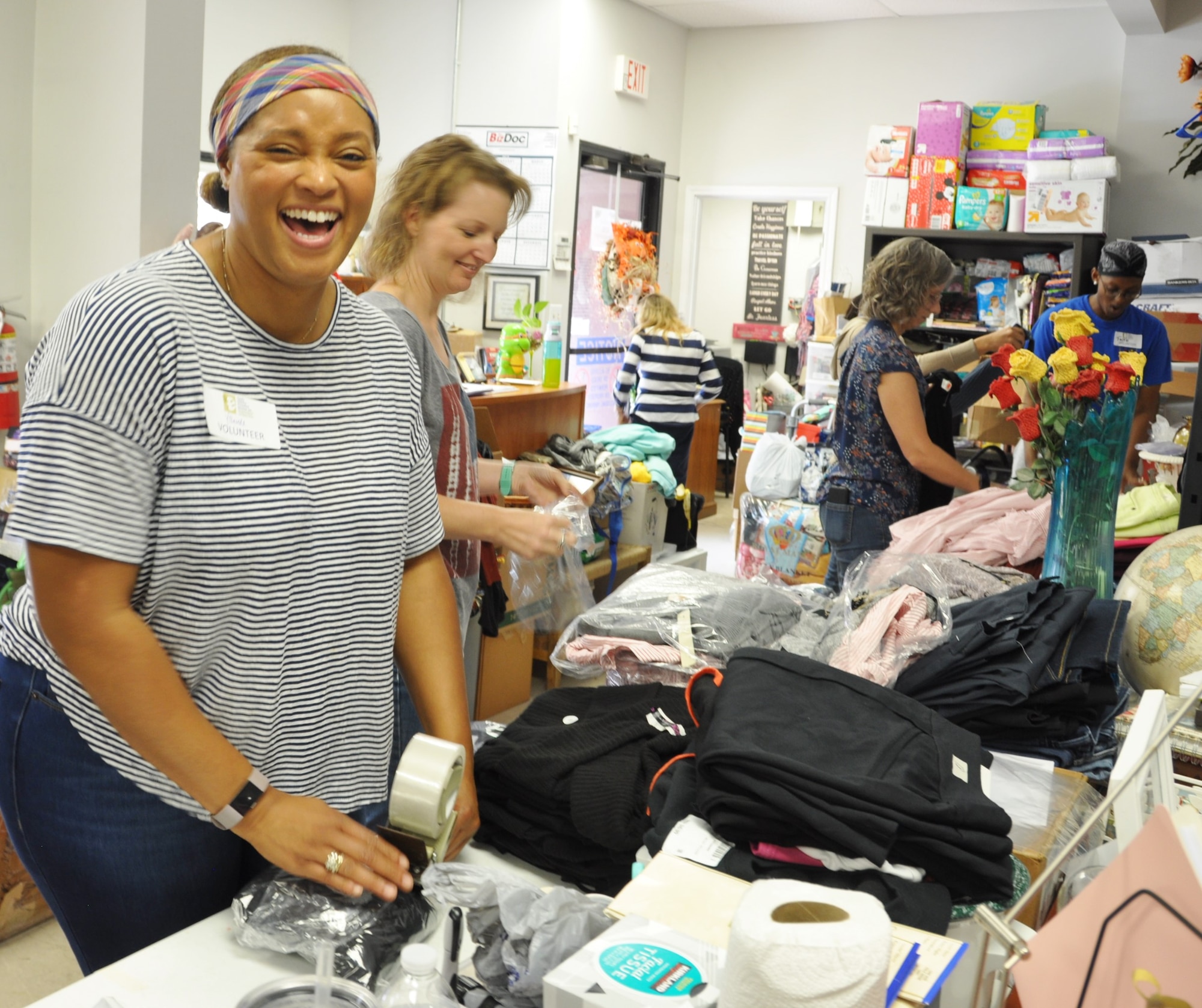 Capt. Yolanda Seals (left) shares a chuckle with fellow 340th Flying Training Group volunteers (left to right) Chastity Ramirez Lt. Col. Teresa Davies and Master Sgt. Faith Wells during the Sept. 11 community outreach event at the San Antonio, Texas Family Violence Prevention Services/Battered Women and Children’s Shelter’s Donation Center. Donation Center Coordinator Mari Ayala Sandoval (background-striped top) opens the door to accept waiting donations. (U.S. Air Force photo by Janis El Shabazz)