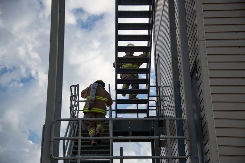 The team from the 97th Healthcare Operations Squadron go up a flight of stairs during the Squadron Commander and First Sergeant Challenge, Sept. 26, 2019, at Altus Air Force Base, Okla. Events during the challenge were timed and required skill and accuracy to mimic daily actions of firefighters. (U.S. Air Force photo by Senior Airman Cody Dowell)