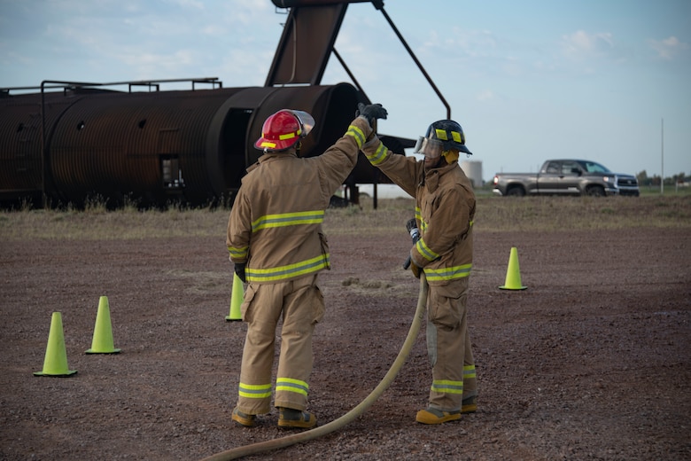 The team for the 54th Aerial Refueling Squadron and 58th Airlift Squadron give each other a high five after finishing the Squadron Commander and First Sergeant Challenge,