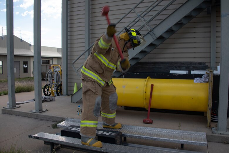 A team member of the 97th Training Squadron team hits a block with a hammer in order to move it the required distance, Sept. 26, 2019, at Altus Air Force Base, Okla.