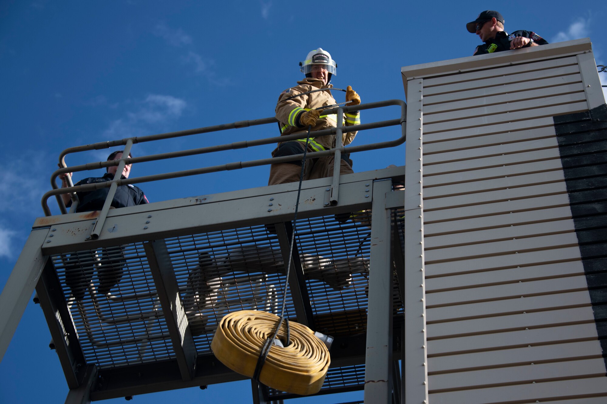 A member of the 97th Civil Engineer Squadron team pulls up a fire house from a rope during the Squadron Commander and First Sergeant Challenge,