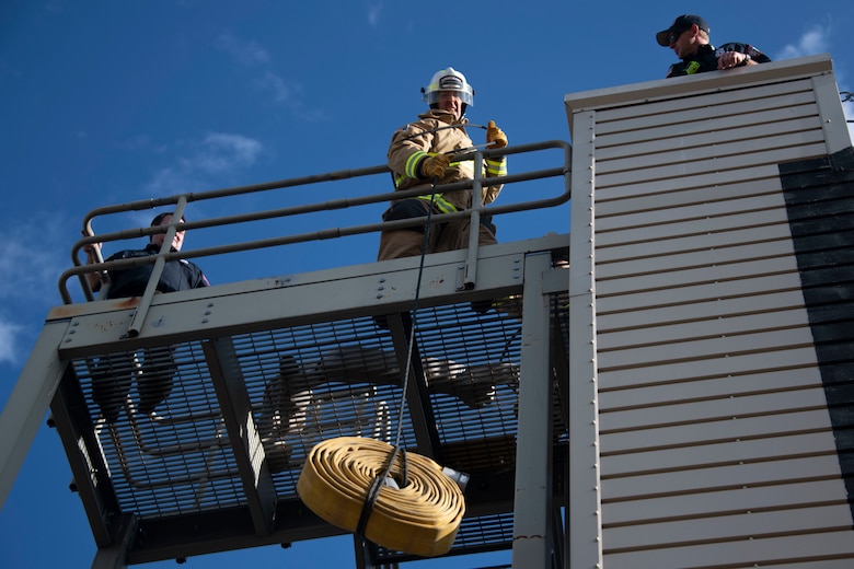 A member of the 97th Civil Engineer Squadron team pulls up a fire house from a rope during the Squadron Commander and First Sergeant Challenge,