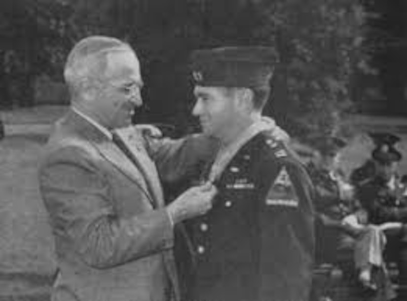 President Harry S. Truman places the Medal of Honor around the neck of Army Capt. James Burt.