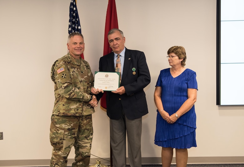 COL Philip Secrist, TAM Commander, hands Mike Graham his certificate of retirement while Mike's wife Shannon looks on. Mike completed 41 years of federal service including 10 as an Army engineer, 28 Sep. 2019.