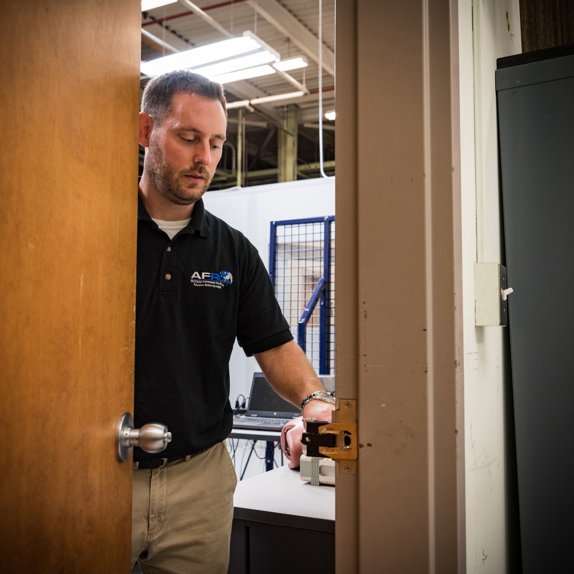 Dr. John McIntire, team lead and research psychologist in the Air Force Research Laboratory’s 711th Human Performance Wing, demonstrates how to use one of the portable door locks his team developed. This team has been selected for a 2019 Defense Innovation Award. (U.S. Air Force photo by Richard Eldridge)