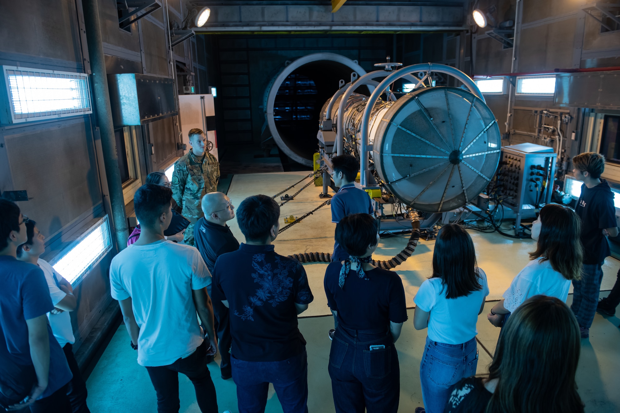 U.S. Staff Sgt. Evan Rogan, 18th Component Maintenance Squadron centralized repair facility craftsman, talks to students about engine test during Air Force Immersion Day, Sept. 23, 2019, at Kadena Air Base, Japan. Air Force Immersion Day is a new community engagement program hosted by the base to teach college and vocational students about the 18th Wing’s role in supporting and defending U.S. and Japanese alliance. (U.S. Air Force photo by Staff Sgt. Micaiah Anthony)