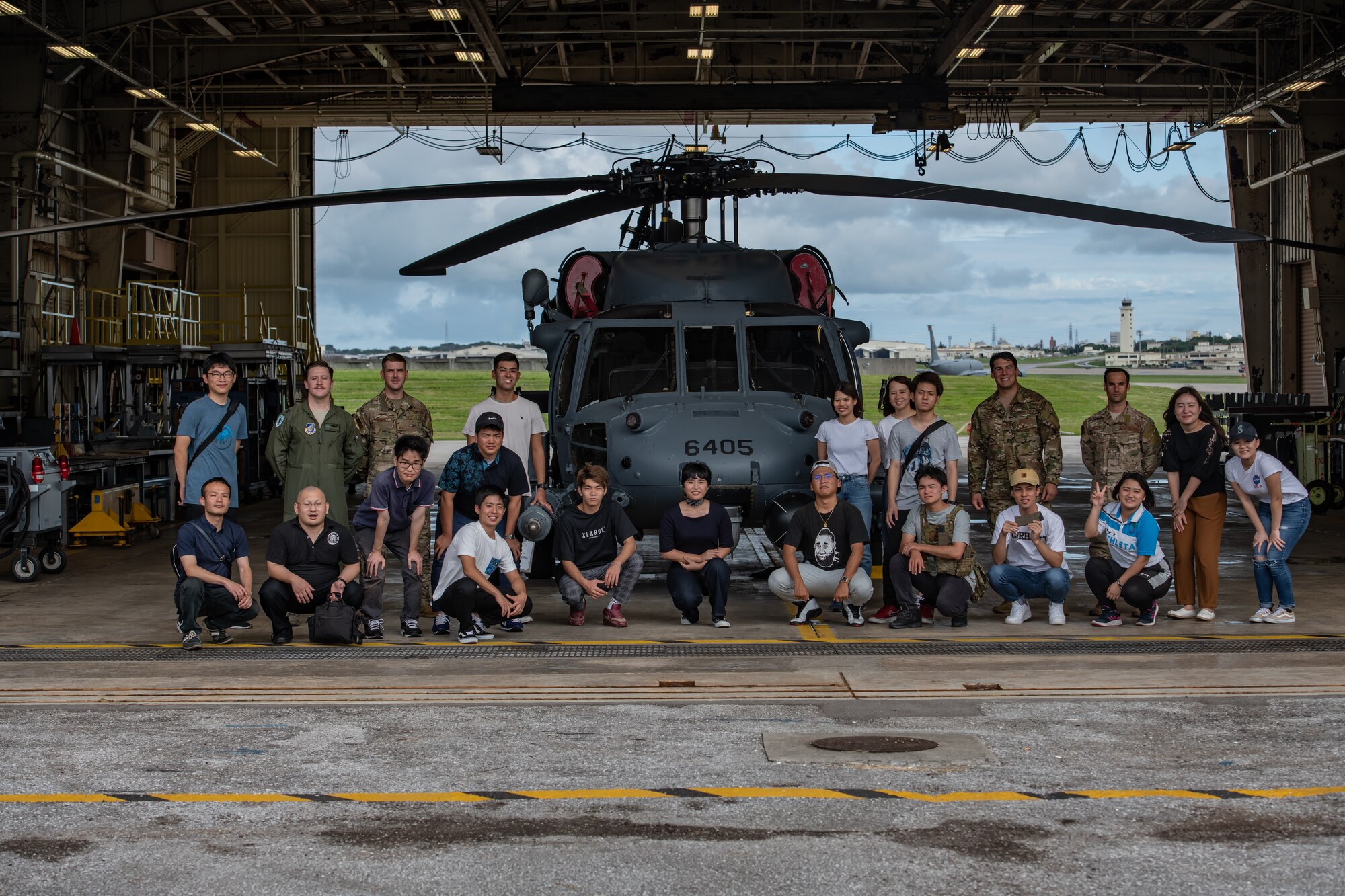 U.S. Air Force Airmen from the 31st and 33rd Rescue Squadrons pose for a photo with local students during Air Force Immersion Day, Sept. 23, 2019, at Kadena Air Base, Japan. Team Kadena invited 18 local university and vocational students to the base to participate in the interactive tour. (U.S. Air Force photo by Staff Sgt. Micaiah Anthony)