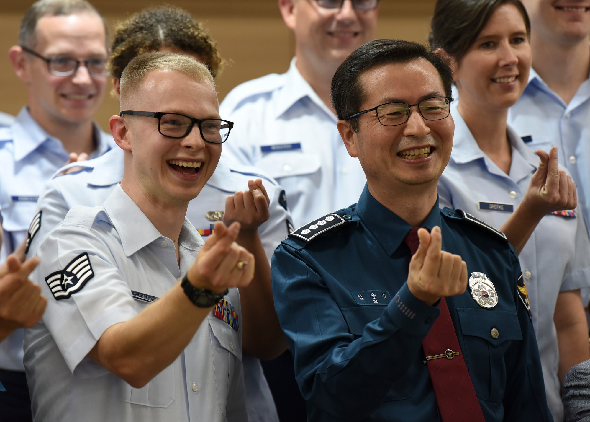 Sang-joon Lim, Gunsan Korean National Police chief, creates the hand heart symbol along with Staff Sgt. Andrew Clemenson, U.S. Air Force Band of the Pacific drummer, and other band members in Gunsan City, Republic of Korea, Sept. 24, 2019. The bands mission is to reinforce alliances, expand partnerships and build cross-cultural trust. (U.S. Air Force photo by Staff Sgt. Anthony Hetlage)