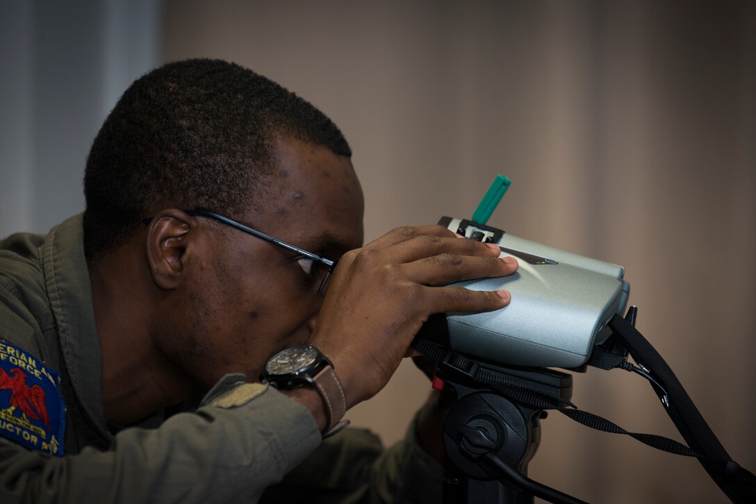 A Nigerian air force pilot peers into a set of virtual reality goggles while conducting simulator training during the 4th Combat Training Squadron’s first Air to Ground Integration Course at Einsiedlerhof Air Station, Germany, Sept. 18, 2019. The course consisted of a week of classroom studies, a week of simulator training, and a capstone event where airmen controlled aircraft on a range.