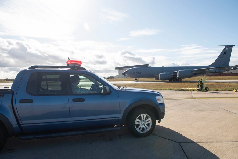 Master Sgt. Scott West, 100th Air Refueling Wing flight safety superintendent, and Tech. Sgt. Jose Martinez, 100th ARW occupational safety manager watch as a KC-135 Stratotanker taxis at RAF Mildenhall, England, Sept. 26, 2019. The nine-person safety office is organized into three different departments: occupational safety, flight safety and weapons safety. (U.S. Air Force photo by Senior Airman Luke Milano)