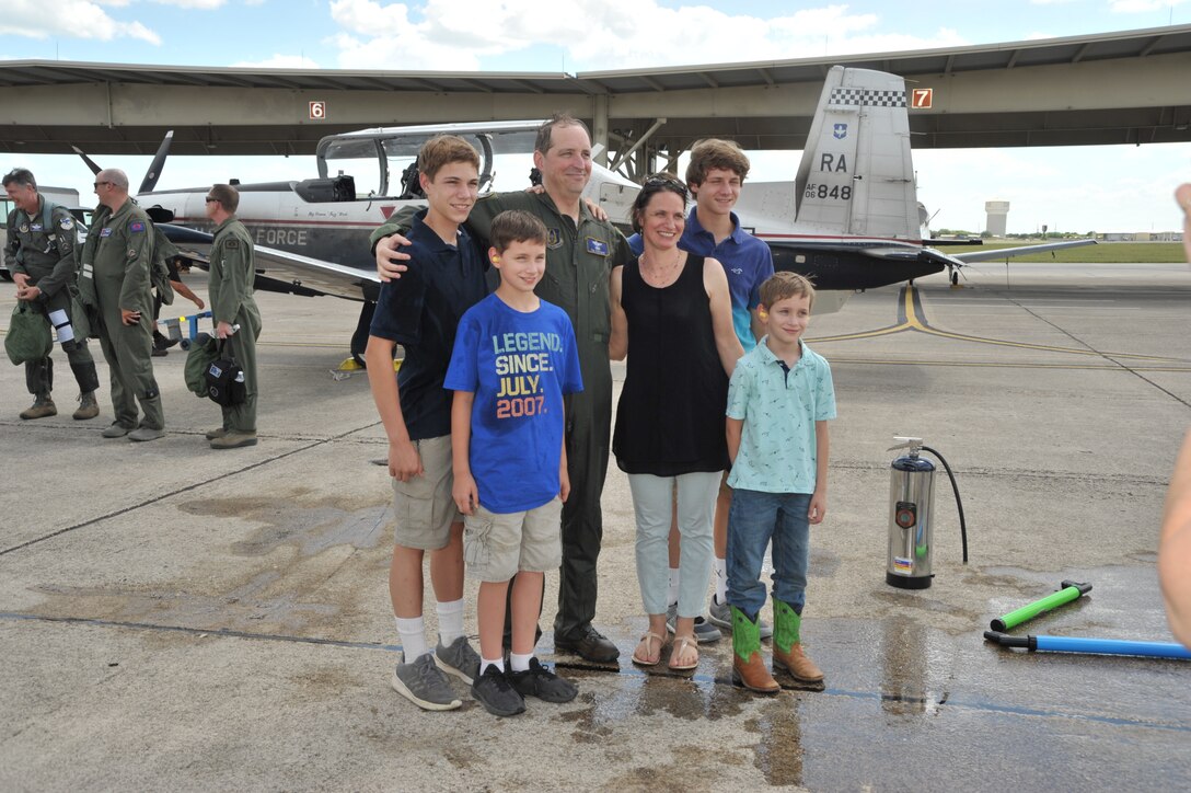 Lt. Col. Timothy Chapman, former 340th Flying Training Group Reserve Undergraduate Flying Training Program manager, poses with wife Christa and their four sons following the colonel's June 18 final flight in the T-6 Texan at Joint Base San Antonio-Randolph, Texas. The fini flight and spray-down are traditional for retiring aircrew members. (U.S. Air Force photo by Debbie Gildea)