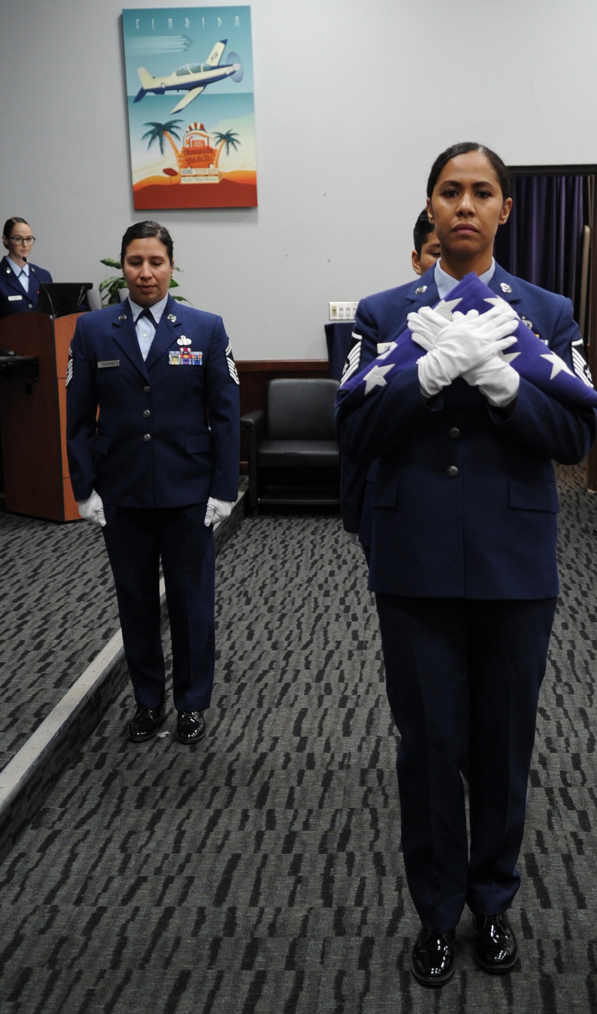 Master Sgt. Tainell Pettengill (front), 340th Flying Training Group Undergraduate Flying Training Program noncommissioned officer in charge, and former UFT NCOIC Senior Master Sgt. Vianca Contreras prepare for the U.S. flag folding ceremony during to Lt. Col. Timothy Chapman, former 340th FTG program manager, during Chapman's Aug. 29 retirement ceremony at Joint Base San Antonio-Randolph, Texas. Also part of the team was former UFT staff member Master Sgt. Digma Norris. Contreras and Norris, now assigned to different units, made the trip to JBSA-Randolph to honor their former boss. (U.S. Air Force photo by Debbie Gildea)