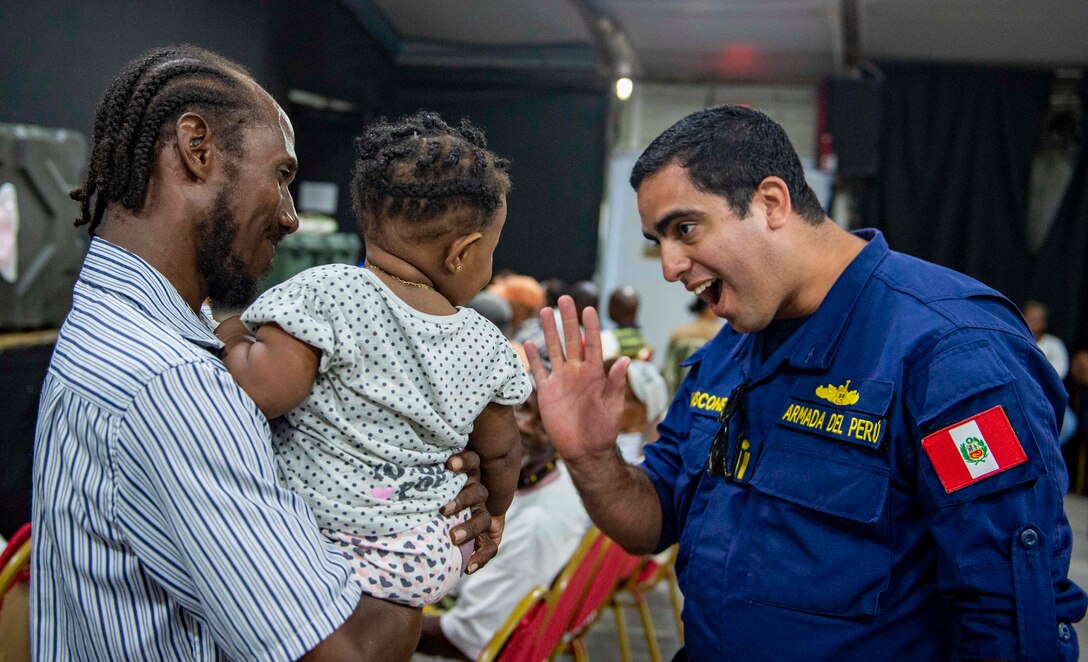 A Peruvian military member greets a Saint Lucian child