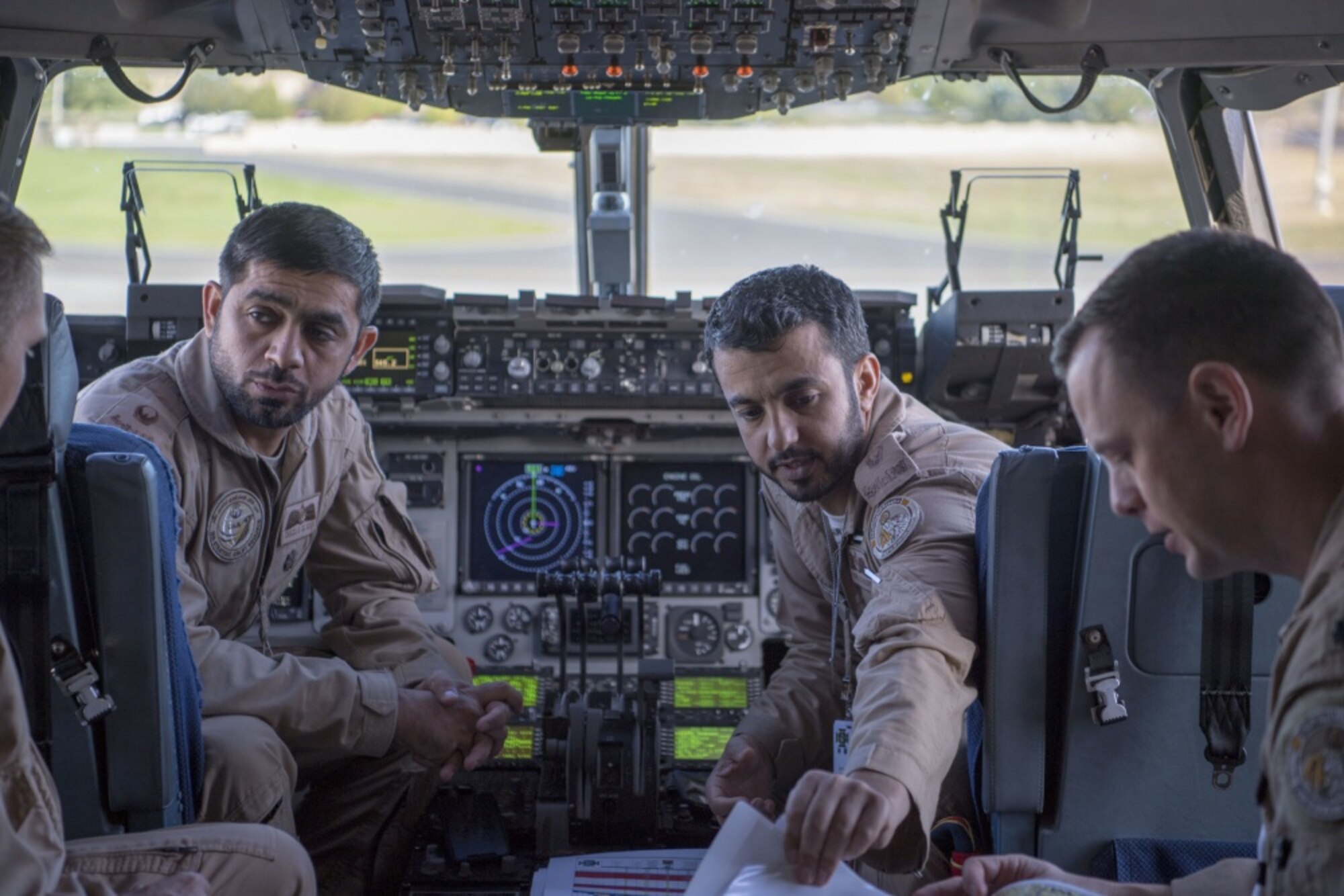 Members of a United Arab Emirates Air Force C-17A Globemaster III, discuss flight plans in preparation for their first conventional airdrop training mission, Sept. 25, 2019, while news media personnel flew aboard during an exercise on Mobility Guardian 2019 media day, over Fairchild Air Force Base, Washington. Exercise Mobility Guardian is Air Mobility Command's premier, large scale mobility exercise. Through robust and relevant training, Mobility Guardian improves the readiness and capabilities of Mobility Airmen to deliver rapid global mobility and builds a more lethal and ready Air Force. (U.S. Air Force photo by Senior Airman Charles T. Fultz)