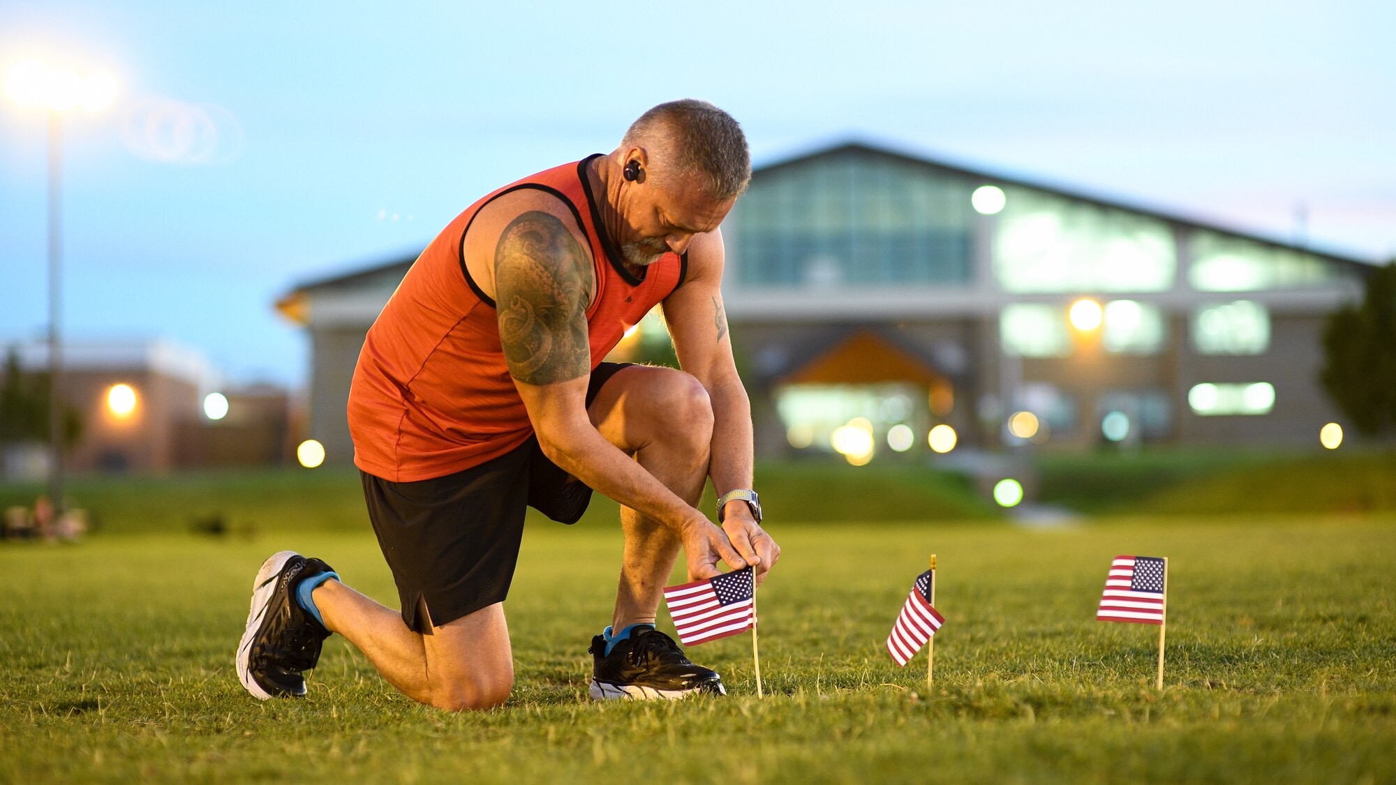 Master Sgt. Jared Barrett places a flag during a Suicide Awareness Prevnetion Month 5K ruck march/run at Hill Air Force Base, Utah, Sept. 25, 2019. Throughout the day and during the ruck march/run, Airmen placed flags in remembrance of a family member, friend or coworker who died by suicide. (U.S. Air Force photo by R. Nial Bradshaw)