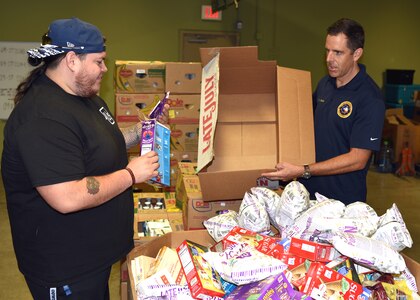 Cmdr. Nicholas Gamiz (right), commanding officer of Navy Recruiting District San Antonio, volunteers at the San Antonio Food Bank Sept. 27.
