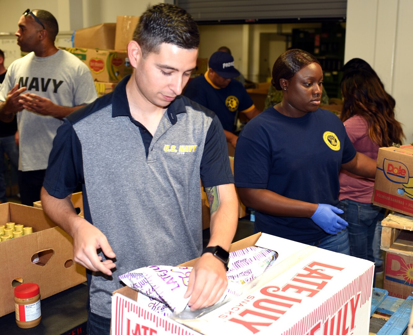 Petty Officer 1st Class Francisco Sierra (left), assigned to Navy Recruiting Station (NRS) North East, and Petty Officer 1st Class Chiemeka Jones, assigned to Navy Recruiting Station South East, volunteer at the San Antonio Food Bank Sept. 27.