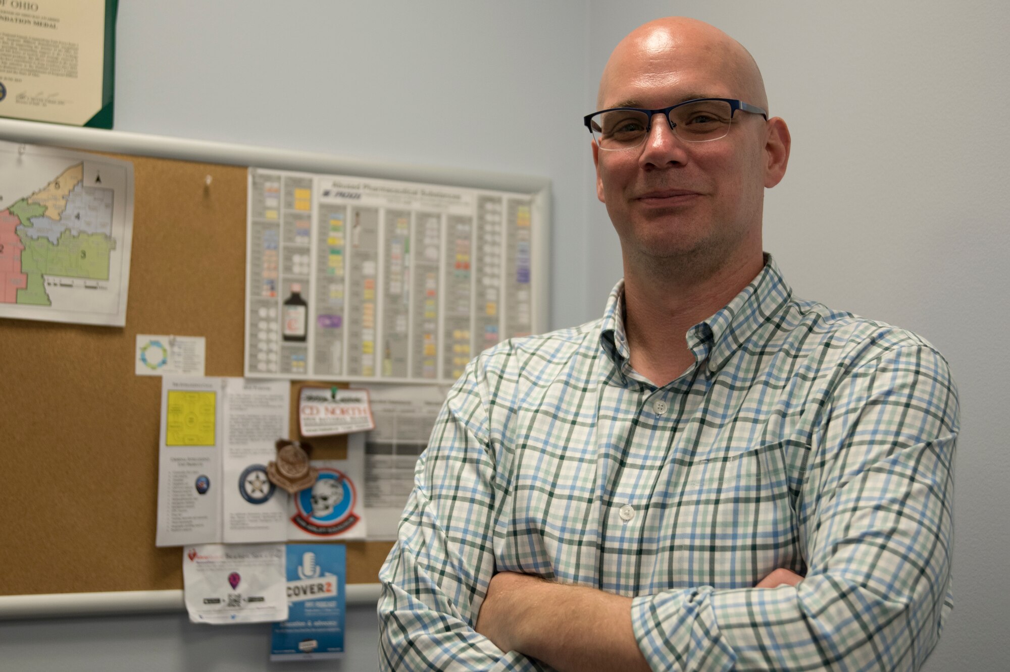 Environmental portrait photo of person standing in front of a bulletin board