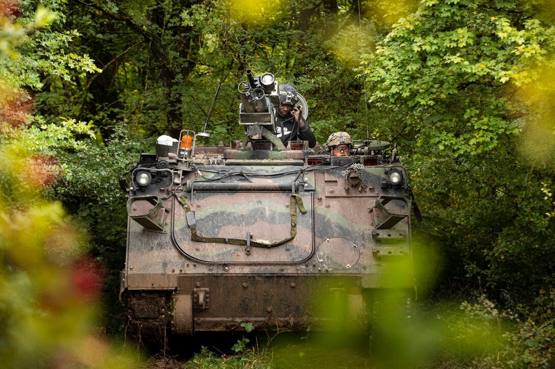 Soldiers ride in a military vehicle.