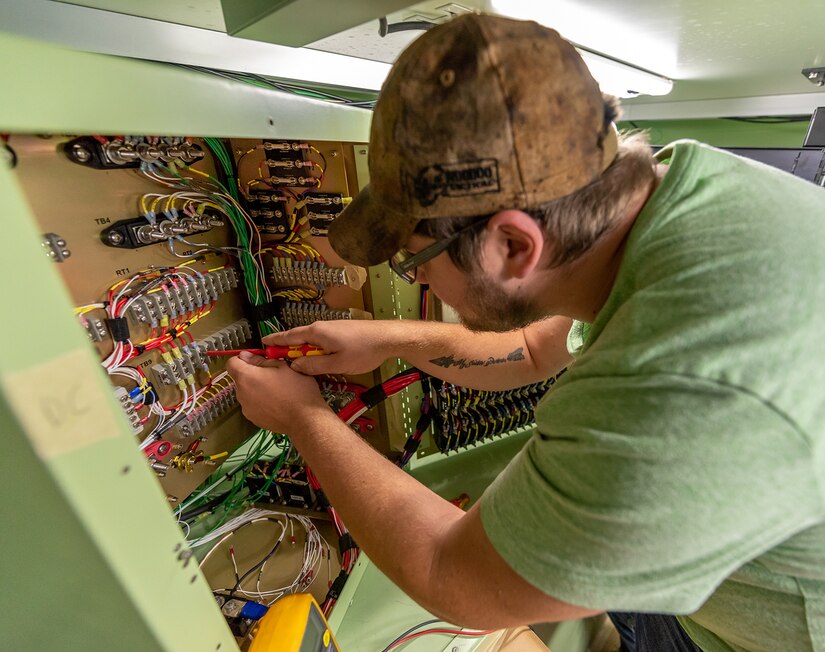 Photo of Electronics Mechanic Helper conducting electrical install and functional tests