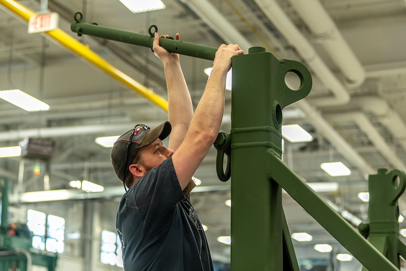 Photo of Industrial Worker Helper installing a railing post on a Power Equipment Group pallet