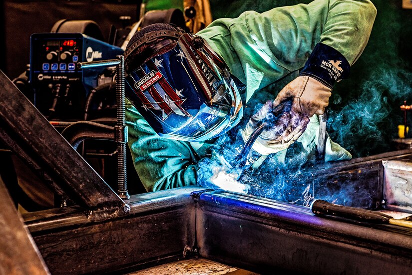 Photo of Welder welding the frame assembly for a Power Equipment Group (PEG) pallet
