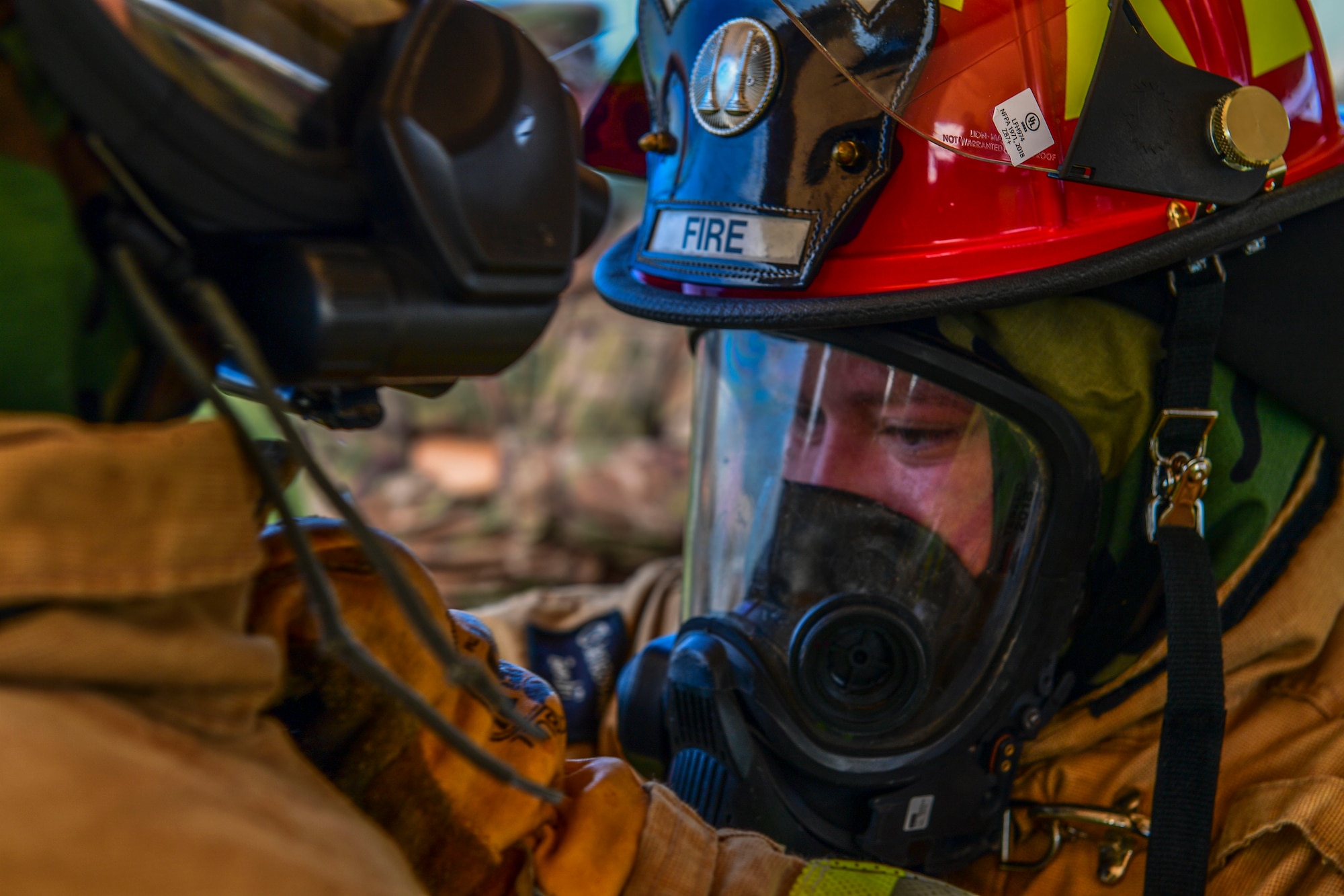 Tech. Sgt. John Mclauglin, station captain with the 171st Fire Emergency Services, unclasps the neck of a fire suit worn by Staff Sgt. Scott Frederick, crew chief with the 171st Fire Emergency Services, during decontamination training in Coraopolis, Pennsylvania, September 8, 2019.