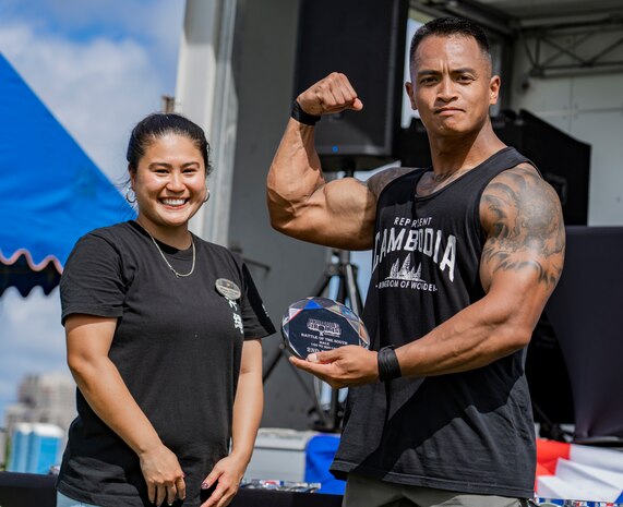 U.S. Marine Corps Gunnery Sgt. Bunnarath Gnoy, heavy equipment staff noncommissioned officer with Marine Wing Support Squadron 172, flexes his bicep after earning 2nd place in his weight class at Okinawa's Strongest: Battle of the South, Sept. 29, 2019 on Camp Foster, Okinawa, Japan. The competition challenges men and women to compete in physically demanding events to find the strongest on the island.